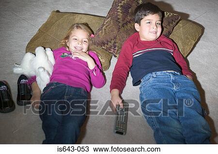 Stock Image - Father hugging daughter mother in background. Fotosearch