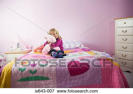 Stock Photo - Girl hugging a toy in her room. Fotosearch