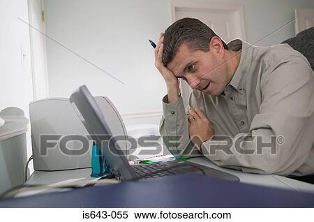 Man looking frustrated at his laptop computer View Large Photo Image Stock Photography - Man looking frustrated at his laptop computer. Fotosearch