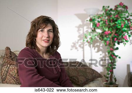 Mid adult woman in her lounge View Large Photo Image Stock Image - Mid adult woman in her lounge. Fotosearch