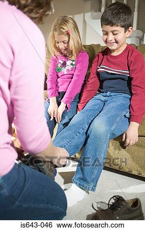 Mother putting on children's' shoes View Large Photo Image Stock Photograph - Mother putting on children's' shoes. Fotosearch