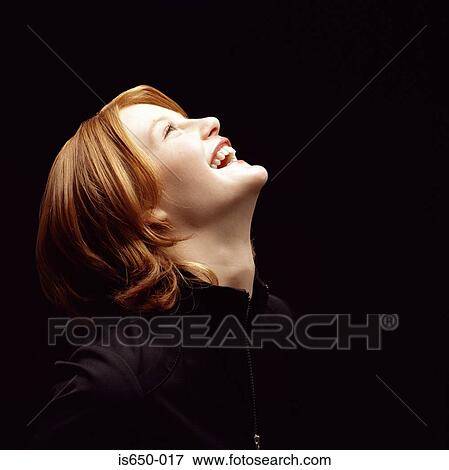 Stock Photo - Young woman looking up with illuminated face. Fotosearch