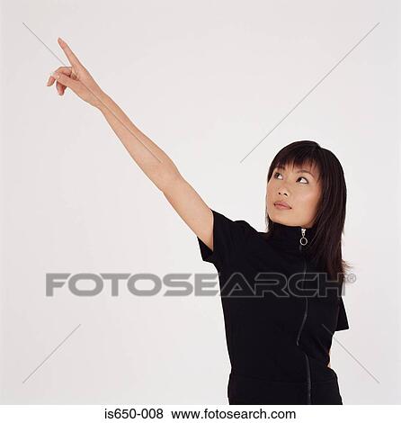 Stock Photo - Young woman pointing upwards. Fotosearch