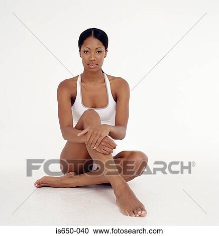 Young woman sitting and holding her leg View Large Photo Image Stock Image - Young woman sitting and holding her leg. Fotosearch