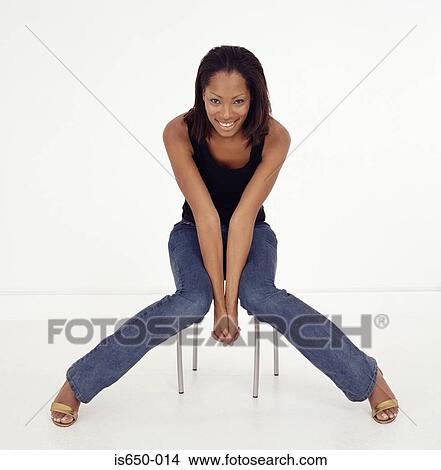 Picture - Young woman sitting on stool. Fotosearch
