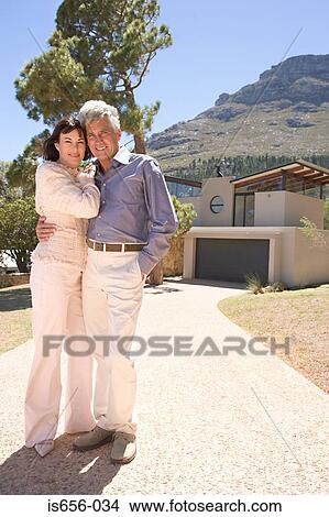 Picture - Couple outside mountainside house. Fotosearch