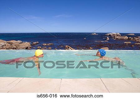 Couple swimming in pool View Large Photo Image Stock Photograph - Couple swimming in pool . Fotosearch