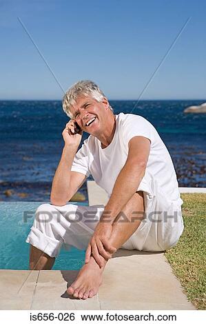 Man by the pool on mobile phone View Large Photo Image Stock Photograph - Man by the pool on mobile phone. Fotosearch