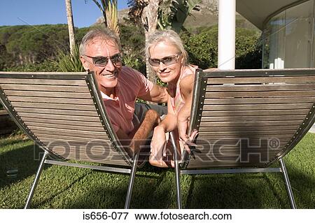 Mature couple in lounge chairs View Large Photo Image Stock Photo - Mature couple in lounge chairs. Fotosearch