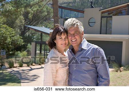 Stock Image - Mature couple outside house . Fotosearch