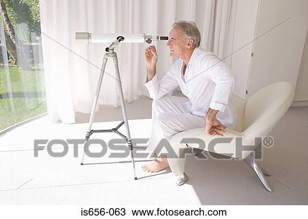 Mature man looking through telescope View Large Photo Image Stock Image - Mature man looking through telescope. Fotosearch