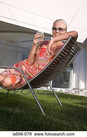 Mature woman in lounge chair View Large Photo Image Stock Photo - Mature woman in lounge chair. Fotosearch