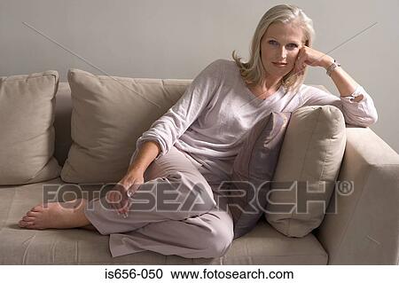 Stock Image - Mature woman on sofa . Fotosearch