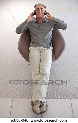 Relaxed man wearing headphones View Large Photo Image Stock Photograph - Relaxed man wearing headphones. Fotosearch