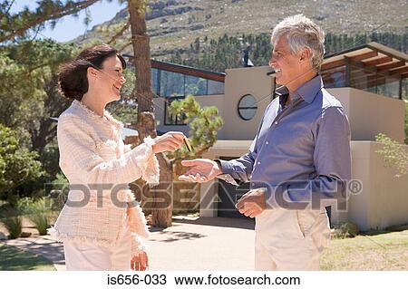 Woman handing keyring to man View Large Photo Image Stock Image - Woman handing keyring to man. Fotosearch