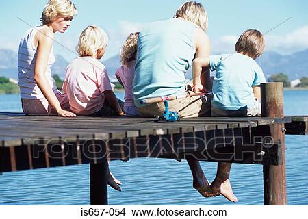 Family sitting on a jetty View Large Photo Image Picture - Family sitting on a jetty. Fotosearch