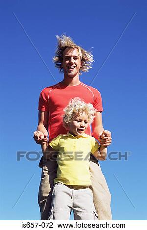Stock Image - Father and son jumping. Fotosearch