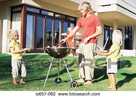 Father doing a barbecue for his family View Large Photo Image Stock Image - Father doing a barbecue for his family. Fotosearch
