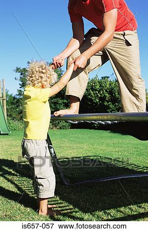 Father helping son onto trampoline View Large Photo Image Stock Photo - Father helping son onto trampoline. Fotosearch