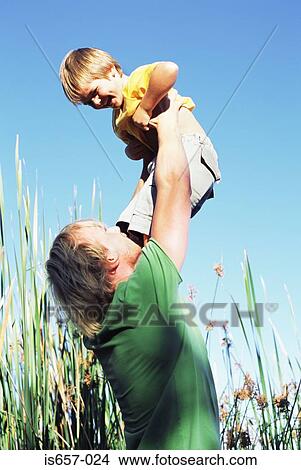 Picture - Father lifting son. Fotosearch