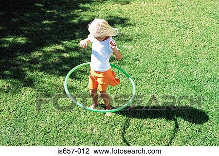 Girl playing with hula hoop View Large Photo Image Stock Image - Girl playing with hula hoop. Fotosearch