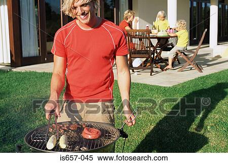 Man doing barbecue for his family View Large Photo Image Stock Photography - Man doing barbecue for his family. Fotosearch