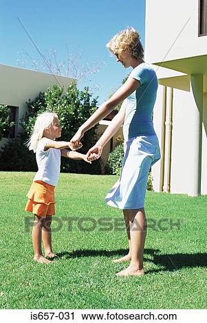 Stock Image - Mother and daughter in garden. Fotosearch