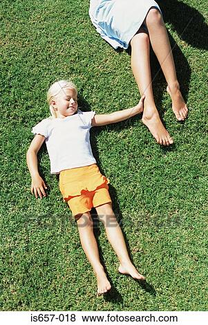 Mother and daughter lying on lawn View Large Photo Image Stock Photo - Mother and daughter lying on lawn. Fotosearch