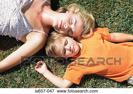 Stock Photo - Mother and son asleep on the lawn. Fotosearch