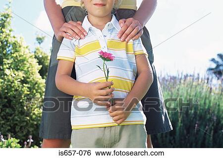 Stock Photograph - Mother with son holding flower. Fotosearch