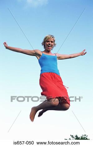 Stock Image - Young woman jumping. Fotosearch