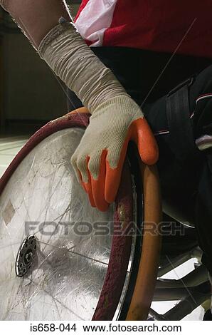Picture - Close-up of hand on a wheelchair. Fotosearch