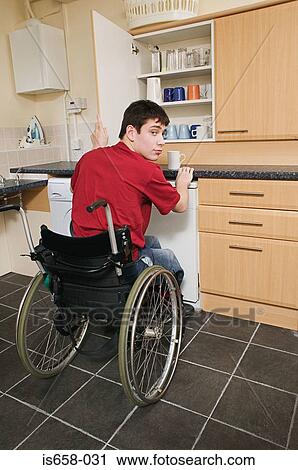 Stock Image - Disabled man in his kitchen. Fotosearch