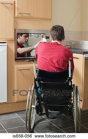 Disabled man opening oven View Large Photo Image Stock Photograph - Disabled man opening oven. Fotosearch