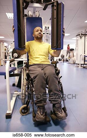 Stock Photography - Disabled man using gym equipment. Fotosearch