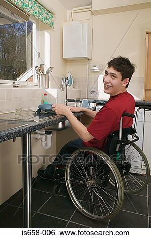 Stock Photograph - Disabled man washing up. Fotosearch