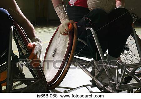Stock Photo - Men a wheelchairs playing basketball. Fotosearch