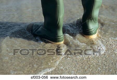 Person in rubber boots standing in sea View Large Photo Image Stock Photograph - Person in rubber boots standing in sea. Fotosearch