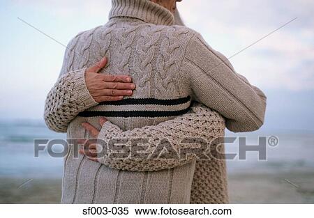 Stock Photography - Rear view of couple hugging on beach. Fotosearch