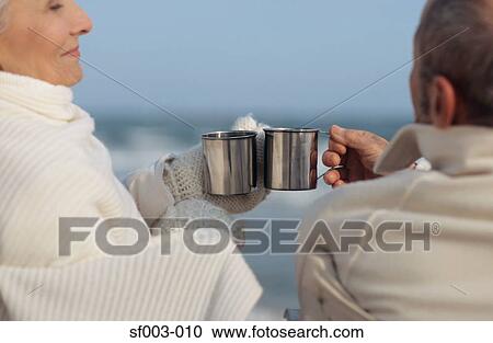Senior couple having a drink on the beach View Large Photo Image Stock Image - Senior couple having a drink on the beach. Fotosearch