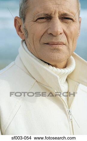 Picture - Senior man at beach looking at camera. Fotosearch