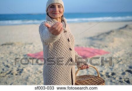 Senior woman holding picnic basket and beckoning View Large Photo Image Stock Image - Senior woman holding picnic basket and beckoning. Fotosearch