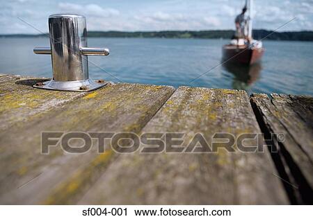 Stock Image - Boat approaching jetty. Fotosearch