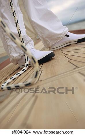 Close-up of feet and rope on deck of boat View Large Photo Image Picture - Close-up of feet and rope on deck of boat. Fotosearch