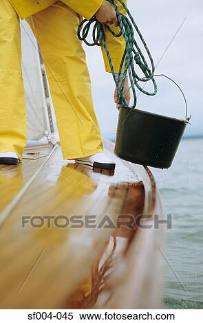 Person on deck of boat holding bucket and rope View Large Photo Image Stock Photography - Person on deck of boat holding bucket and rope. Fotosearch
