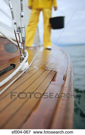 Person standing on deck of boat holding bucket View Large Photo Image Stock Photo - Person standing on deck of boat holding bucket. Fotosearch