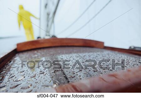 Rear view of person on boat in yellow waterproofs View Large Photo Image Stock Photo - Rear view of person on boat in yellow waterproofs. Fotosearch