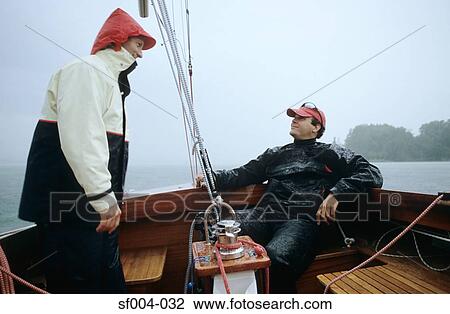 Two men on a boat in the rain View Large Photo Image Stock Image - Two men on a boat in the rain. Fotosearch