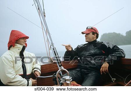 Two men sitting and talking on a boat View Large Photo Image Stock Photo - Two men sitting and talking on a boat. Fotosearch