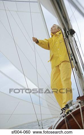Woman adjusting sail on boat View Large Photo Image Stock Image - Woman adjusting sail on boat. Fotosearch